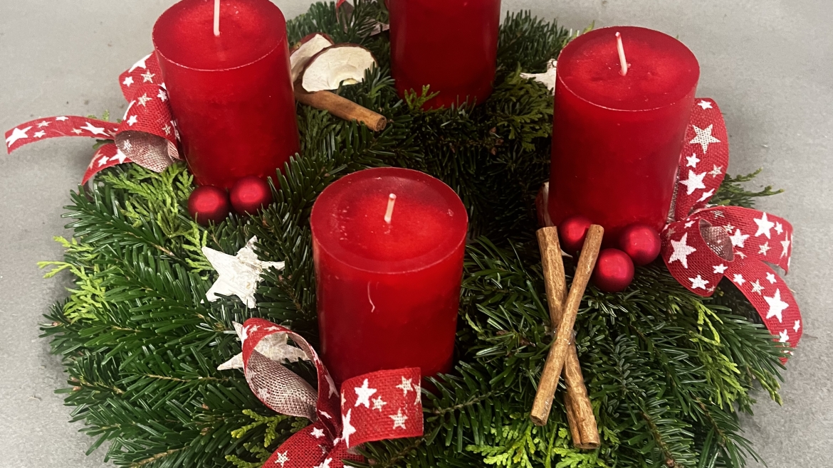 Geflochtener Adventskranz aus Tannen und Thujen mit roten Kerzen